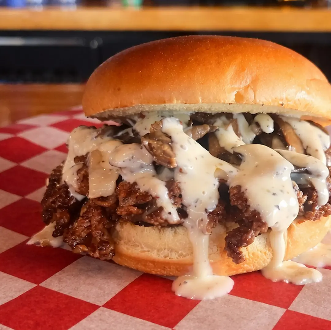 Crow’s Nest smash burger topped with Swiss cheese, stacked sautéed mushrooms, and house No. 07 sauce on a toasted bun at Wilson’s Bar & Grill in Hilliard Ohio