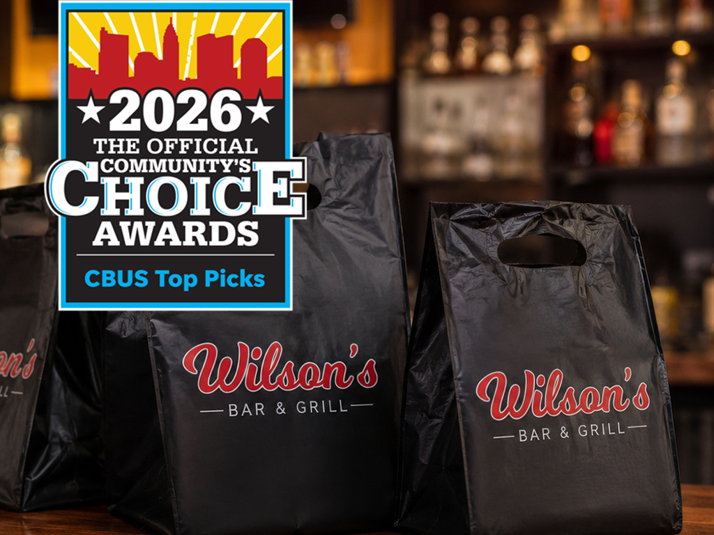 Black Wilson’s Bar & Grill takeout bags on the bar counter in Hilliard, Ohio.