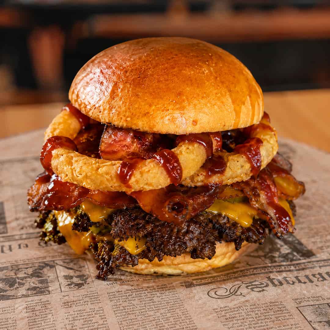 Backyard BBQ Bacon Smash burger with American cheese, hardwood-smoked bacon, hand-breaded onion rings, pickles and barbecue sauce at Wilson’s Bar & Grill in Hilliard, Ohio.