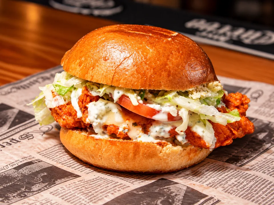 Buffalo chicken sandwich with lettuce, tomato and creamy sauce at Wilson’s
